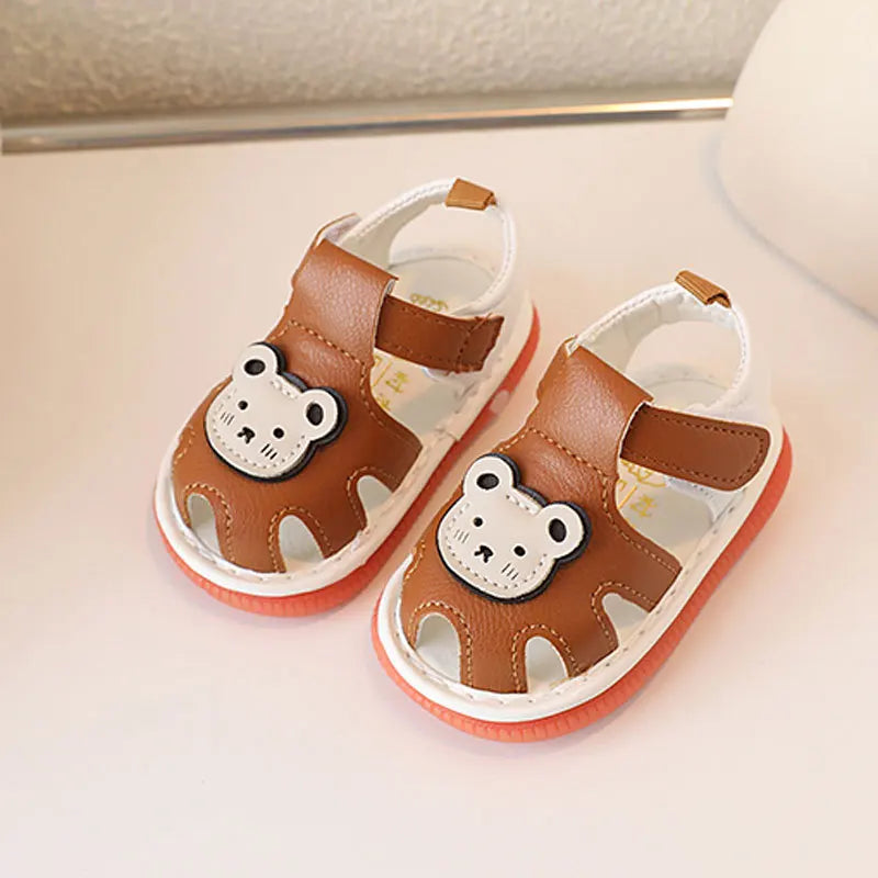 A pair of brown bear soft sole sandals for infants and toddlers resting on a white surface.
