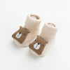 Pair of beige cotton socks with a brown bear face design for babies and toddlers