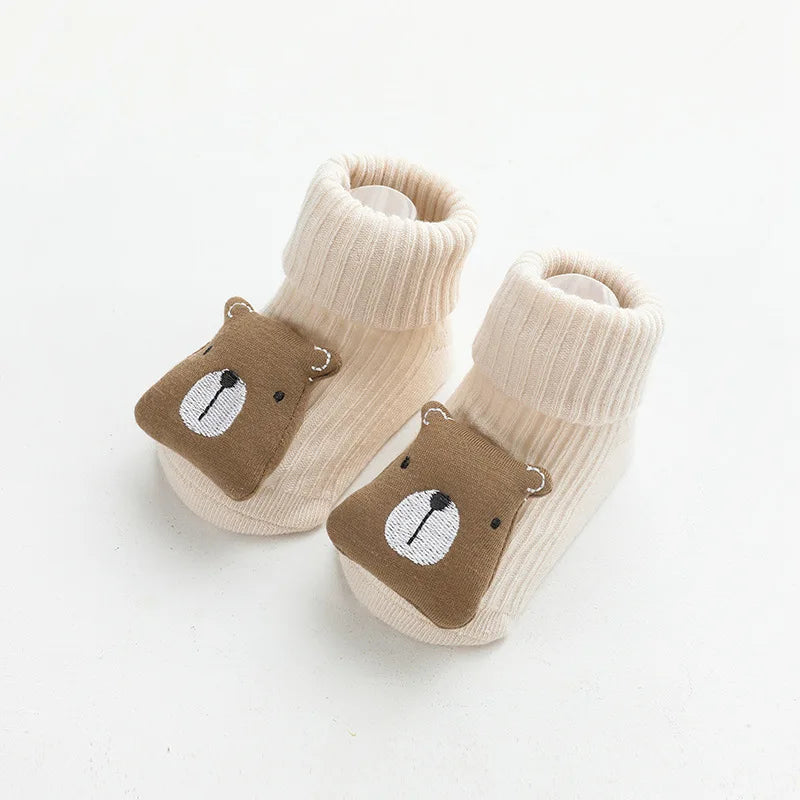 Pair of beige cotton socks with a brown bear face design for babies and toddlers