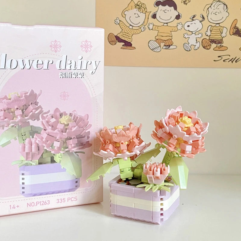 A pink and white miniature flower bouquet building block set displayed next to its packaging.