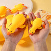 Hands holding a yellow squishy duck stress relief toy against a light yellow background.