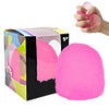 A hand is squeezing a bright pink slow rise squishy stress ball, next to its packaging box.