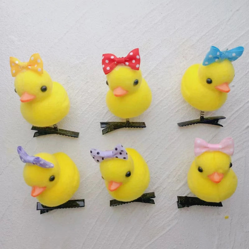A collection of yellow duck plush hair clips with various colored bows attached.