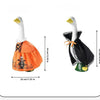 A white goose decoration with an orange festive body and black accents, suitable for seasonal porch decor.
