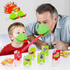 A man and a child play a card game using frog masks and tongue-catching cards on a table.