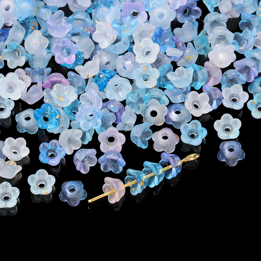 A pile of gradient blue and purple bellflower acrylic beads for jewelry making