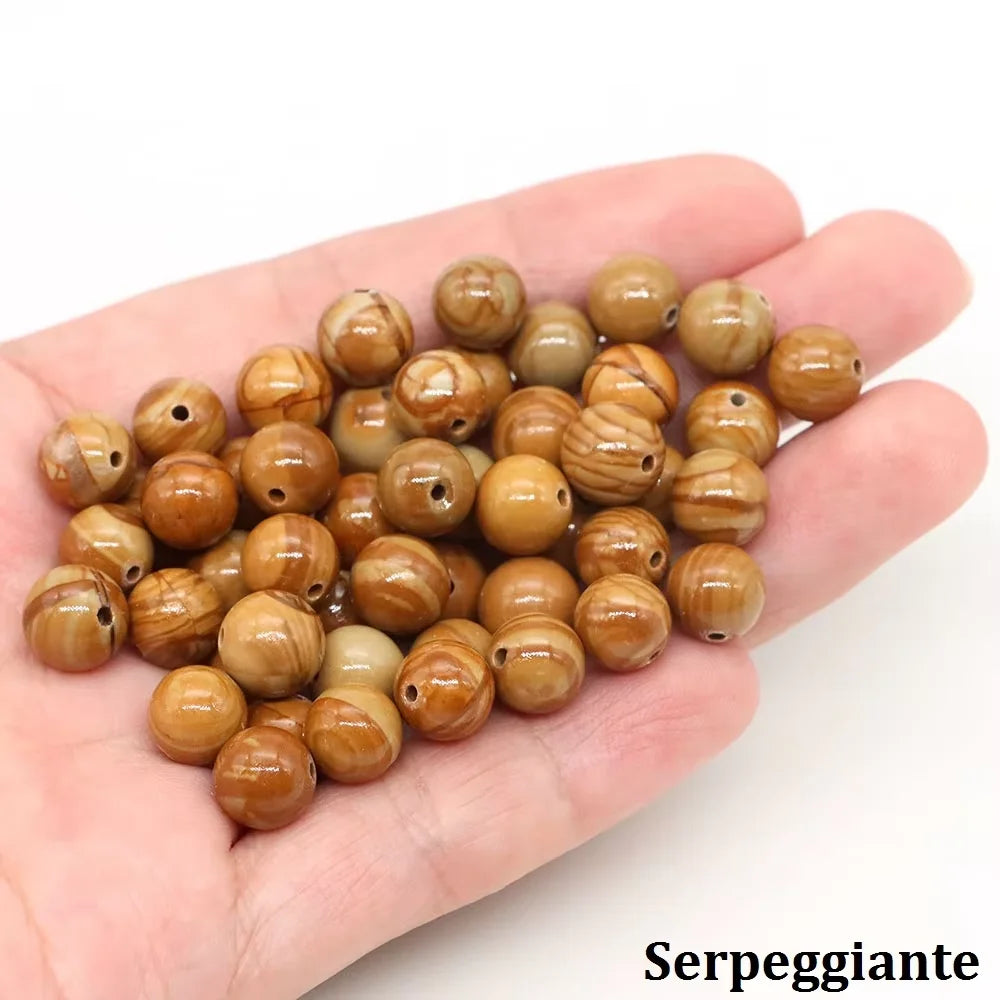 A handful of natural stone round beads in various shades of brown and beige for jewelry making