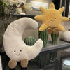 A set of plush toys featuring a yellow sun and a white crescent moon, displayed on a shelf.