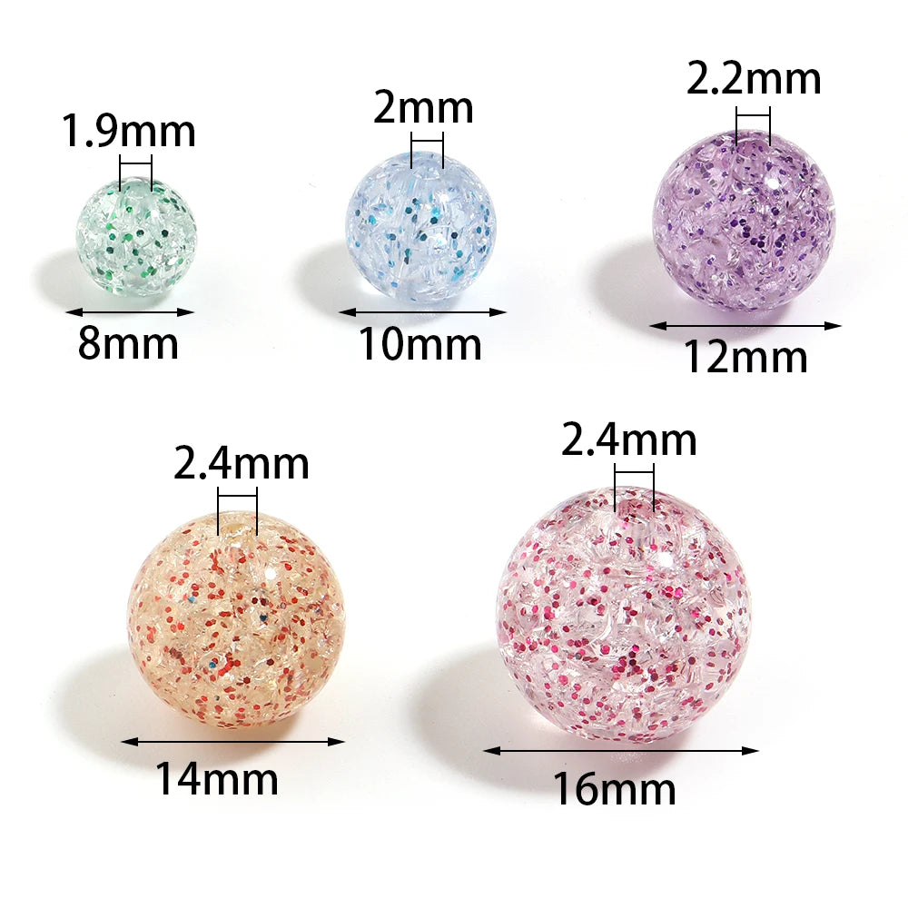 A set of round loose spacer beads made of glitter cracked acrylic in various sizes and shades of purple and pink.