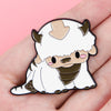 A white cat enamel pin featuring horns and a brown snout, designed for accessories.