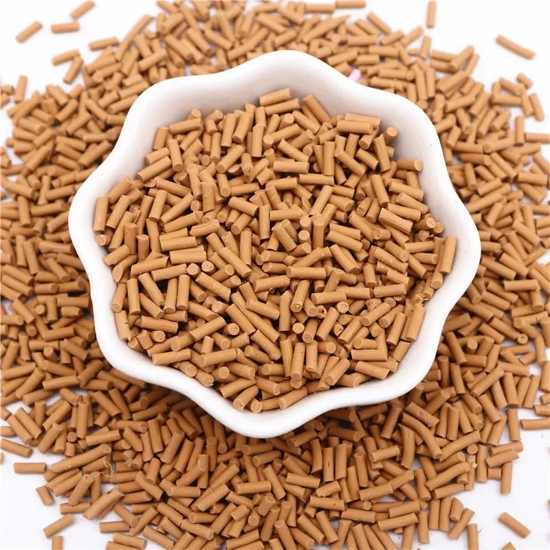 A pile of brown polymer clay slice sprinkles scattered on a white background.