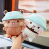 A person is holding a light blue and brown panda bear plush toy.