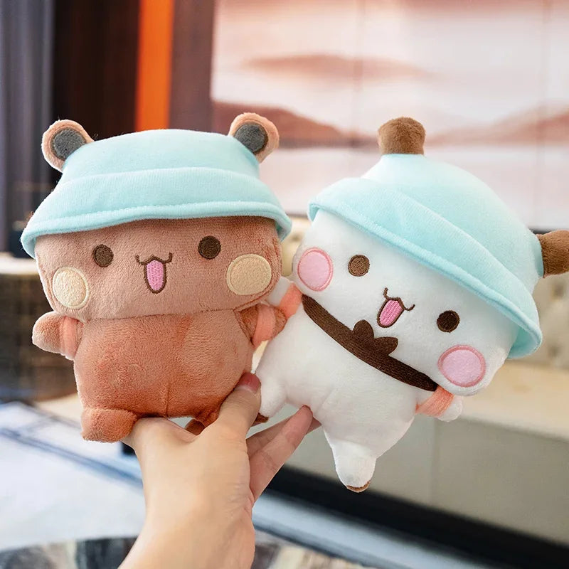 A person is holding a light blue and brown panda bear plush toy.
