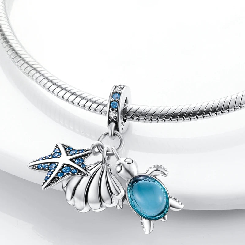 Sterling silver charm pendant set featuring a starfish, sea turtle, and whale shark against a white background