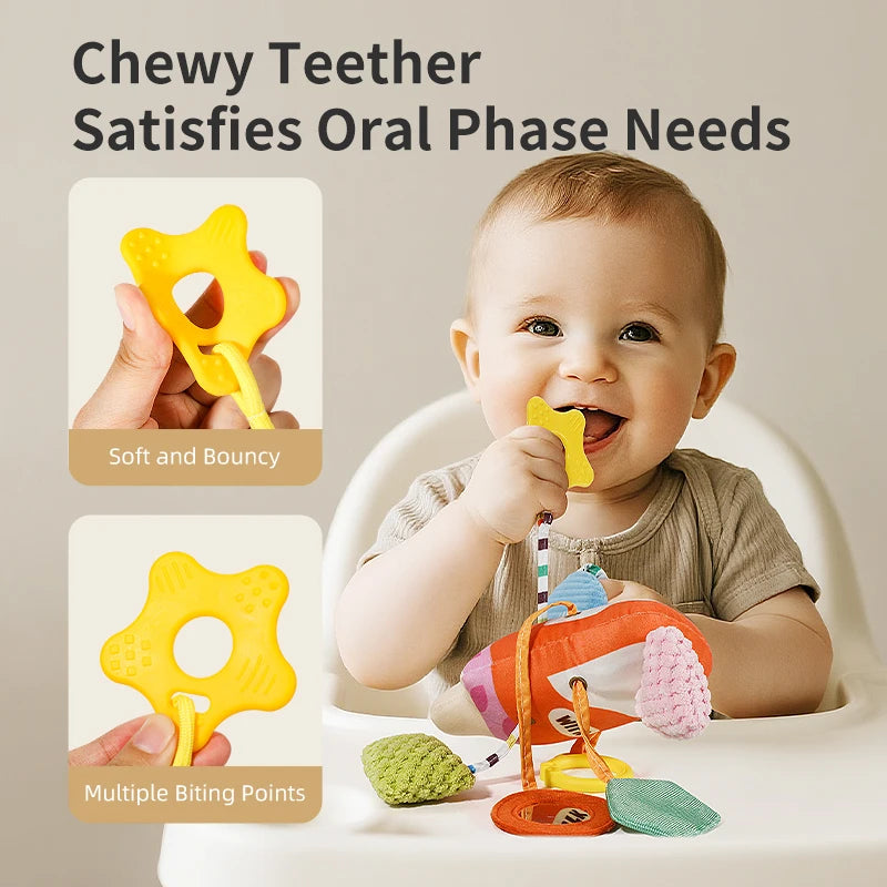 A baby is using a yellow chewy teether toy while sitting in a white bowl, with other teethers nearby.