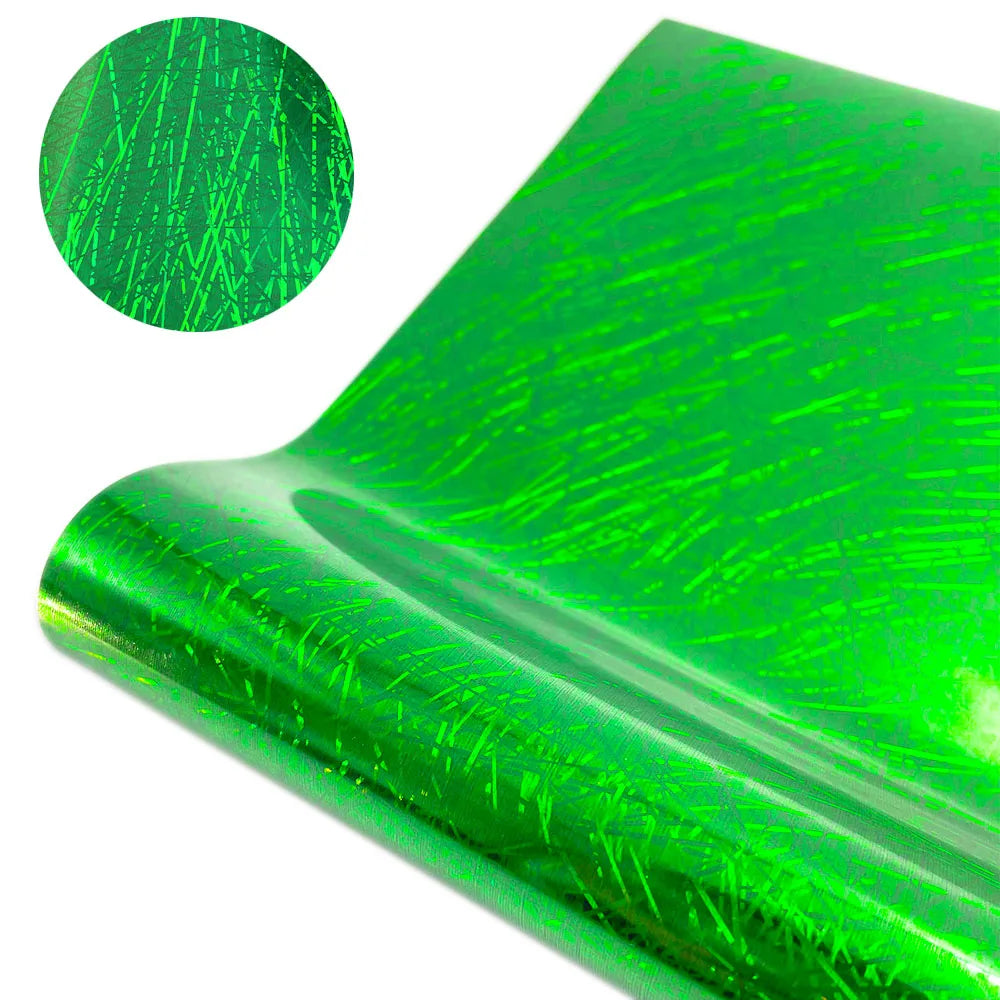A close-up view of green glitter holographic vinyl material, showing a textured surface and a rolled edge.