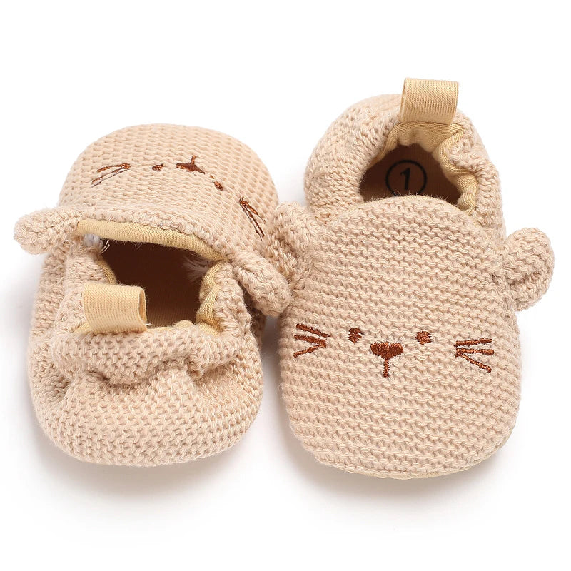 Pair of beige knitted baby walking shoes shaped like cats
