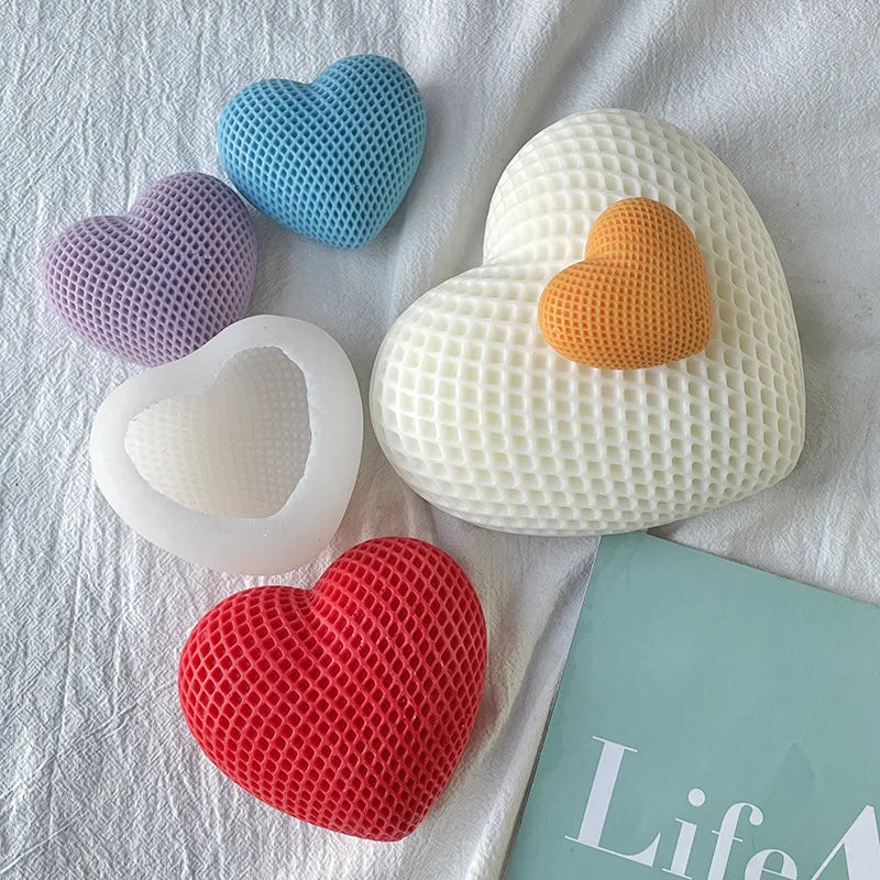 A collection of heart-shaped silicone molds in various colors including blue, purple, orange, and white resting on a white cl