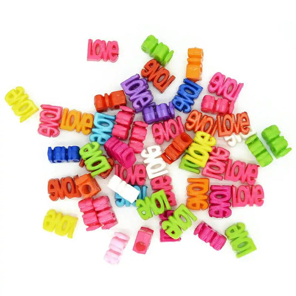Un assortiment de perles acryliques colorées en forme de cœur, dans des tons de rose, violet, vert et orange.