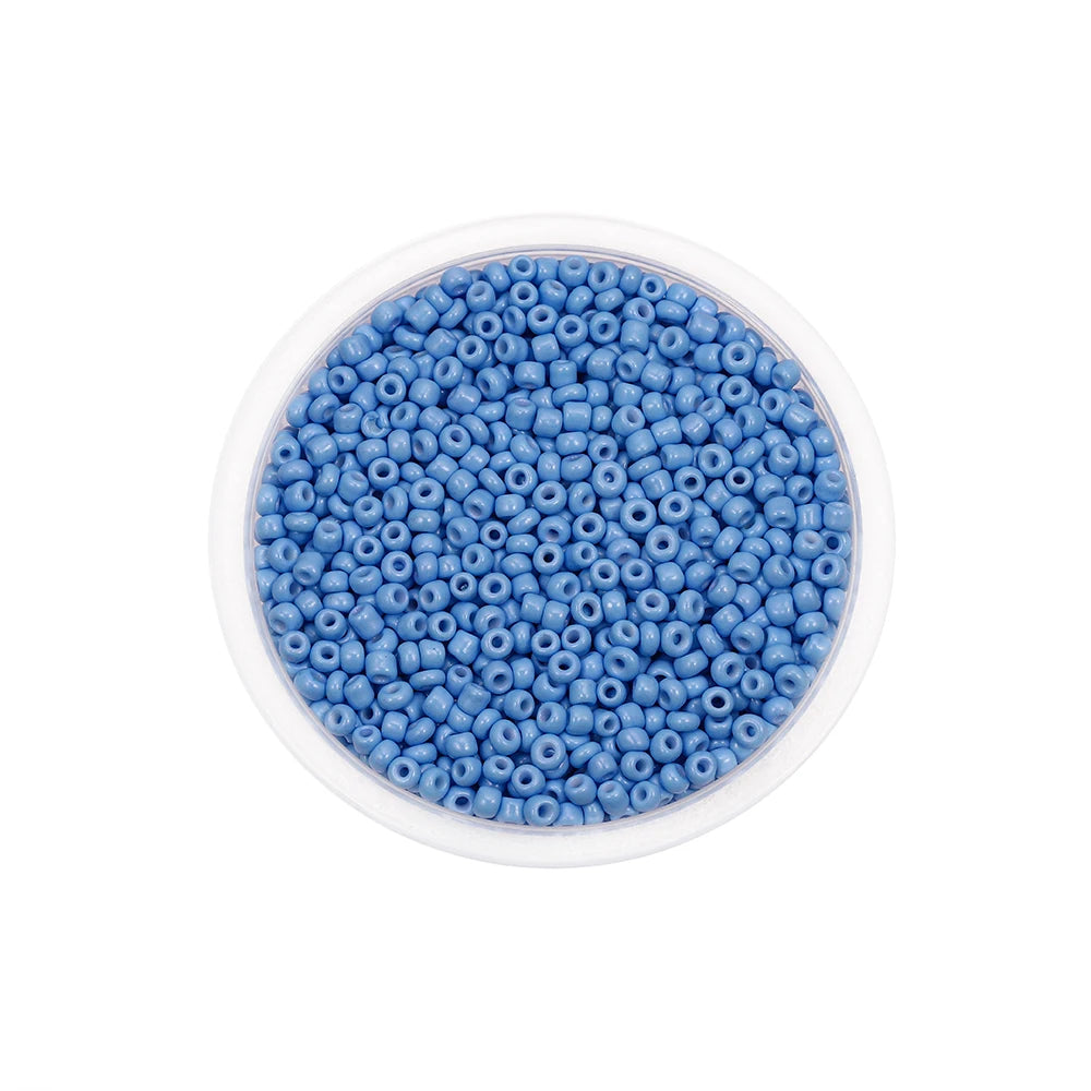 A clear container filled with small, round, blue glass seed beads for jewelry making.
