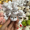 A close-up of various handcrafted crochet animal keychains including rabbits, chicks, cats, and dogs.