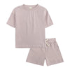 A light mauve kids summer tracksuit set featuring a short sleeve top and matching shorts.