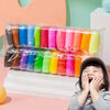 A child is smiling while holding a plastic package of colorful air dry clay for creative modeling fun.