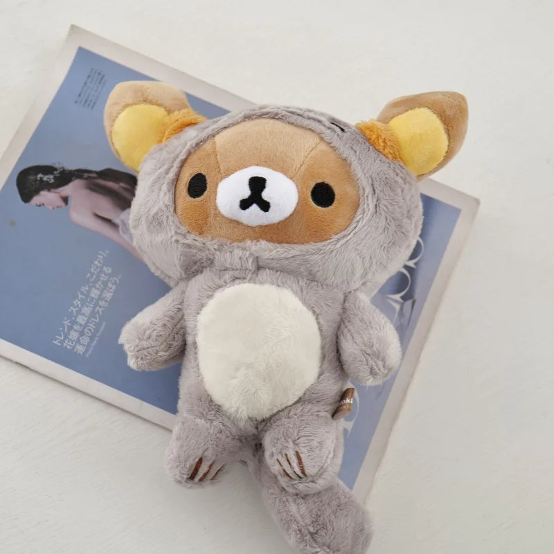 A soft gray Kawaii Rilakkuma Strawberry Bear plush toy sitting on a light blue background.