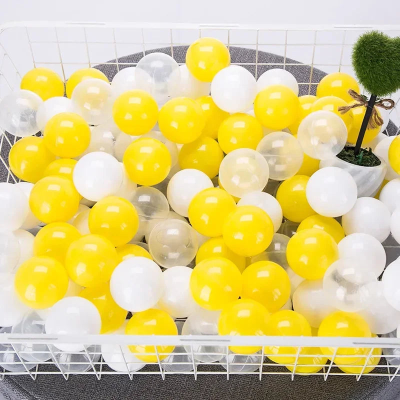 A tray filled with a mix of yellow and white clear plastic play balls for games
