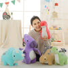 A collection of adorable soft plush dinosaur toys including a blue triceratops, purple dinosaur, and tan dinosaur.