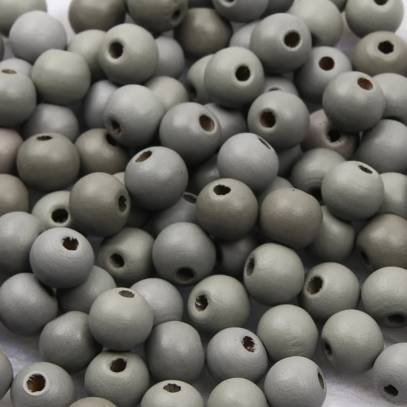 A pile of natural wooden beads in various shades of gray and brown for jewelry making and crafts.