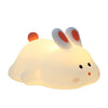 A cute silicone rabbit night light with touch sensor emitting a soft white glow.