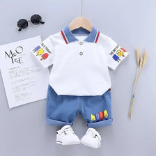 A white short sleeve t-shirt and matching blue denim shorts set for a boy, displayed on a hanger.
