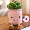 A pink plush stuffed toy shaped like a smiling succulent plant with small brown feet.