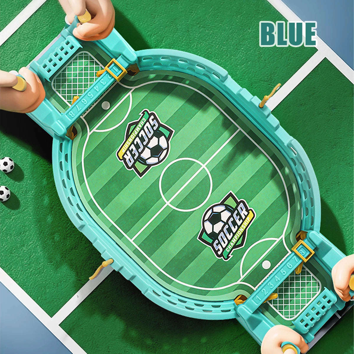 A blue tabletop foosball game with a green playing field and soccer motifs is being held by hands.