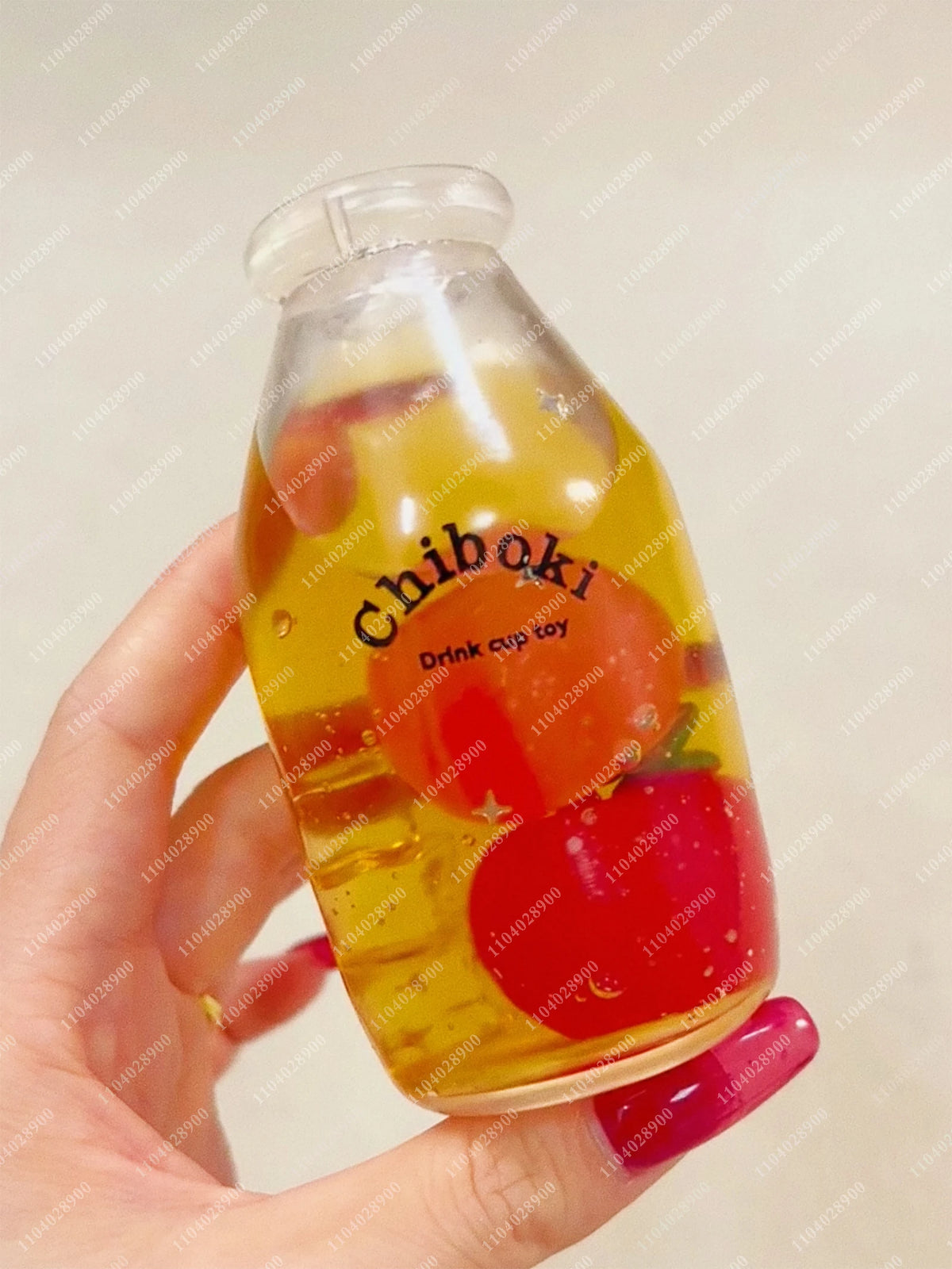 A clear bottle filled with liquid and fruit pieces is held in a hand, labeled Chiboki drink cup toy.