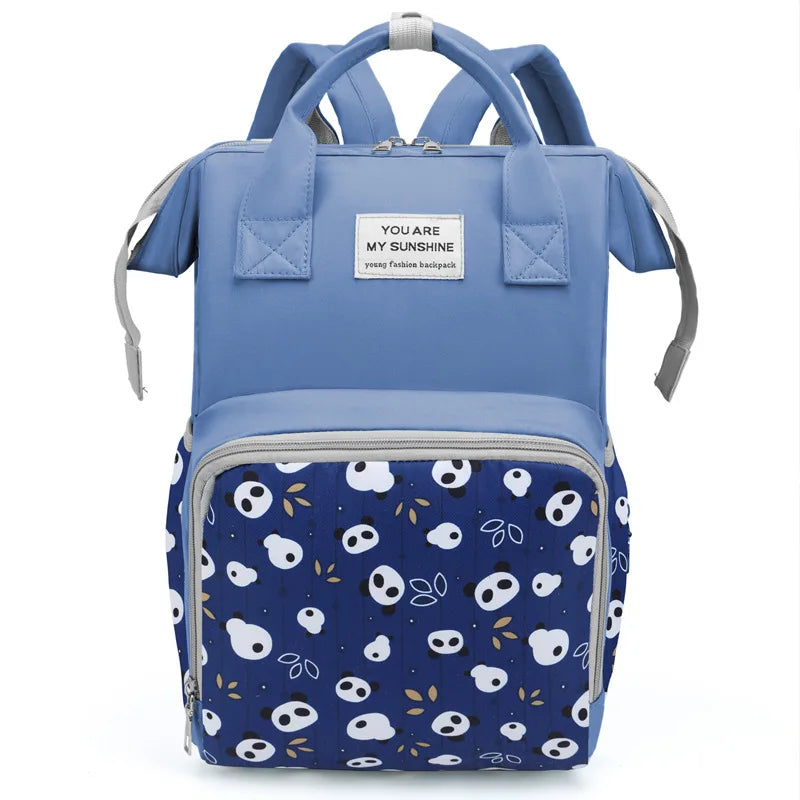 Light blue mommy backpack with a patterned fabric featuring white and black panda faces