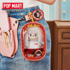 A pink LABUBU doll hair salon bag with a white wig and accessories is attached to a denim jean pocket.