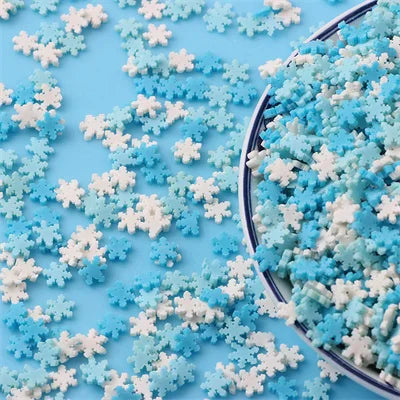 A pile of mixed blue and white polymer clay sprinkles scattered on a light blue surface.