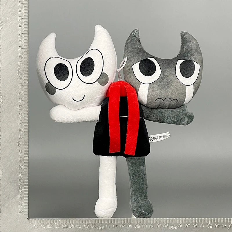 A plush toy resembling a cat face with large eyes and gray fur, displayed against a gray background.