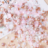 A pile of mixed resin rhinestone pearls with an AB finish in various shades of pink and nude for crafts and nail art.