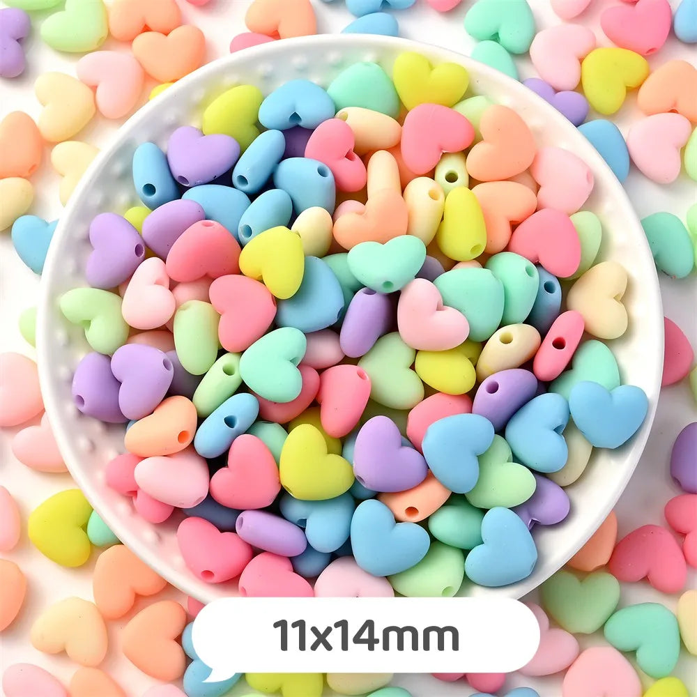 A bowl filled with pastel bear-shaped acrylic craft beads in various shades of pink, yellow, green, and blue.