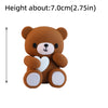 A small, round brown bear cake topper with a white nose and heart details.