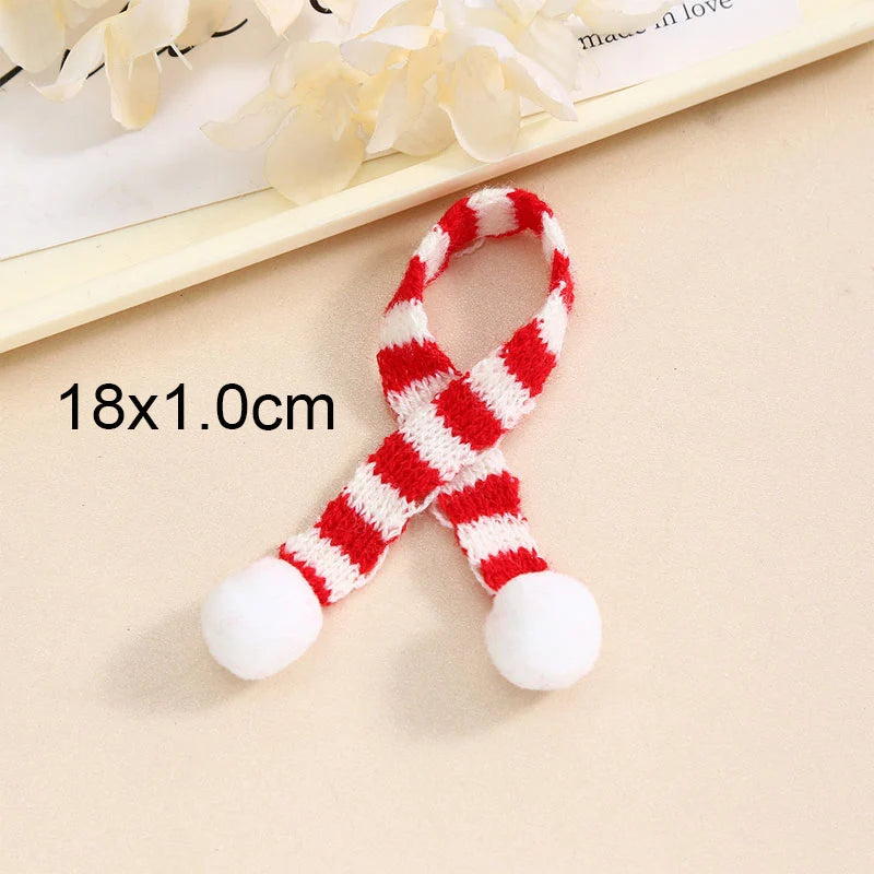A set of mini knit Christmas hats and scarves featuring red and white stripes with white pom-poms.