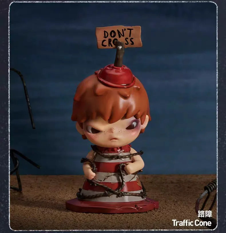 A collectible figurine of a character with reddish-brown hair and a red hat, standing on a brown surface.