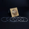 A package of classical guitar strings with a silver-plated core is displayed on a dark surface.