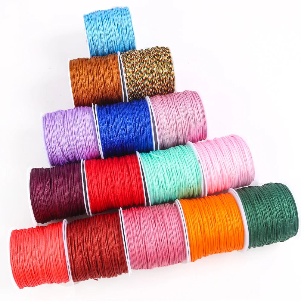 A stack of colorful macrame cord rolls in various shades including blue, orange, pink, and green.