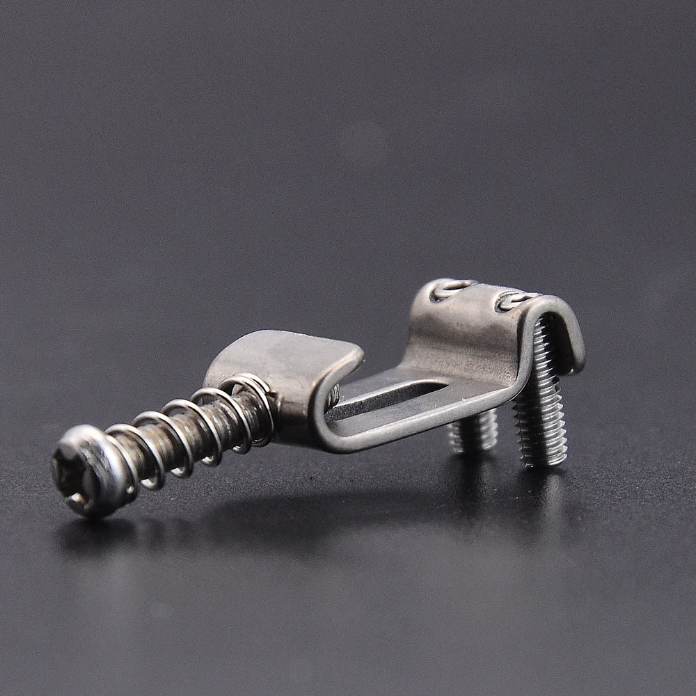 A titanium alloy electric guitar bridge saddle set with a threaded post and clamping mechanism.