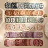 A collection of vintage floral stickers in various shades of blue, green, and pink arranged in rows for scrapbooking.