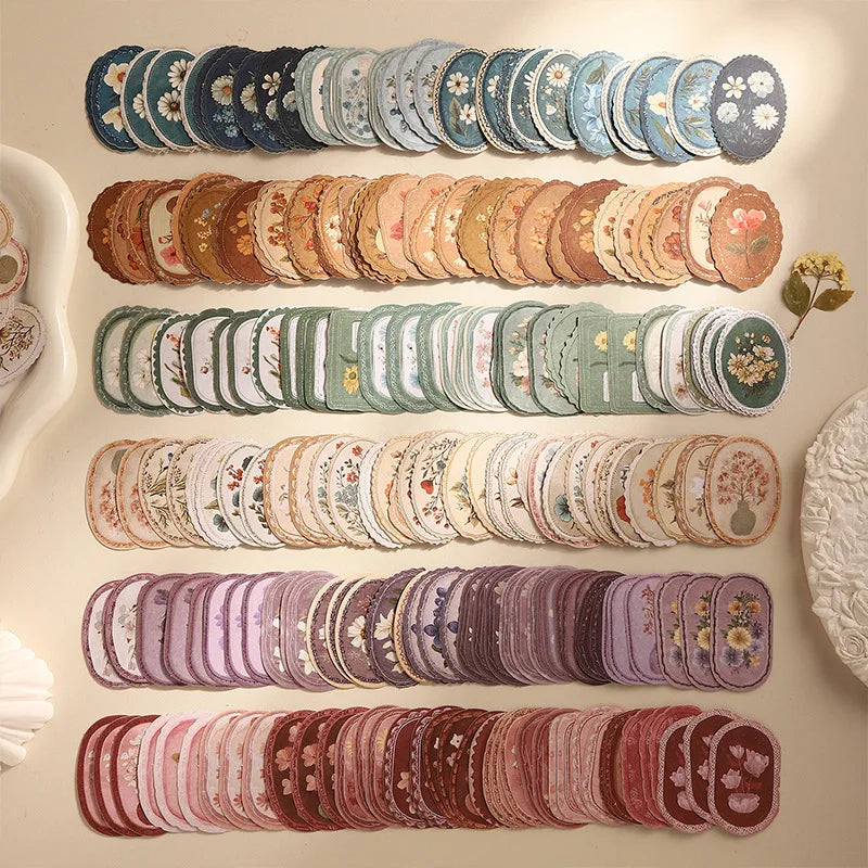 A collection of vintage floral stickers in various shades of blue, green, and pink arranged in rows for scrapbooking.